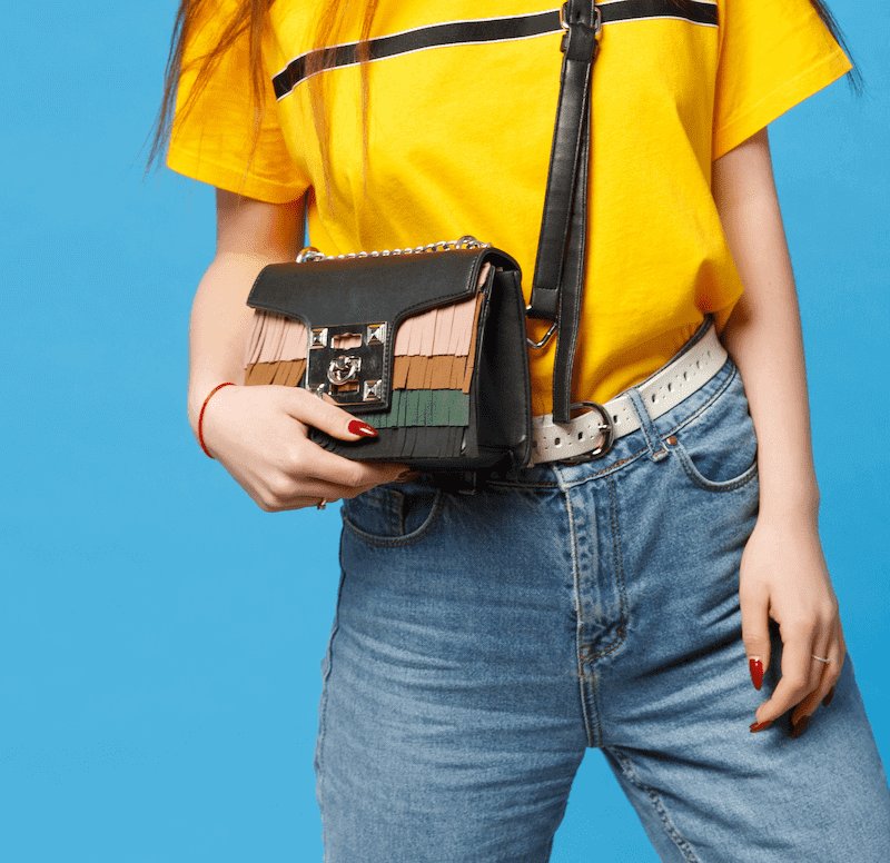 person in yellow shirt and jeans with crossbody bag