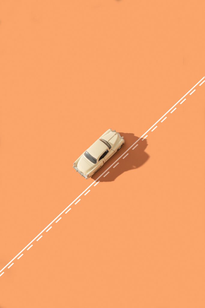 orange car driving alongside road