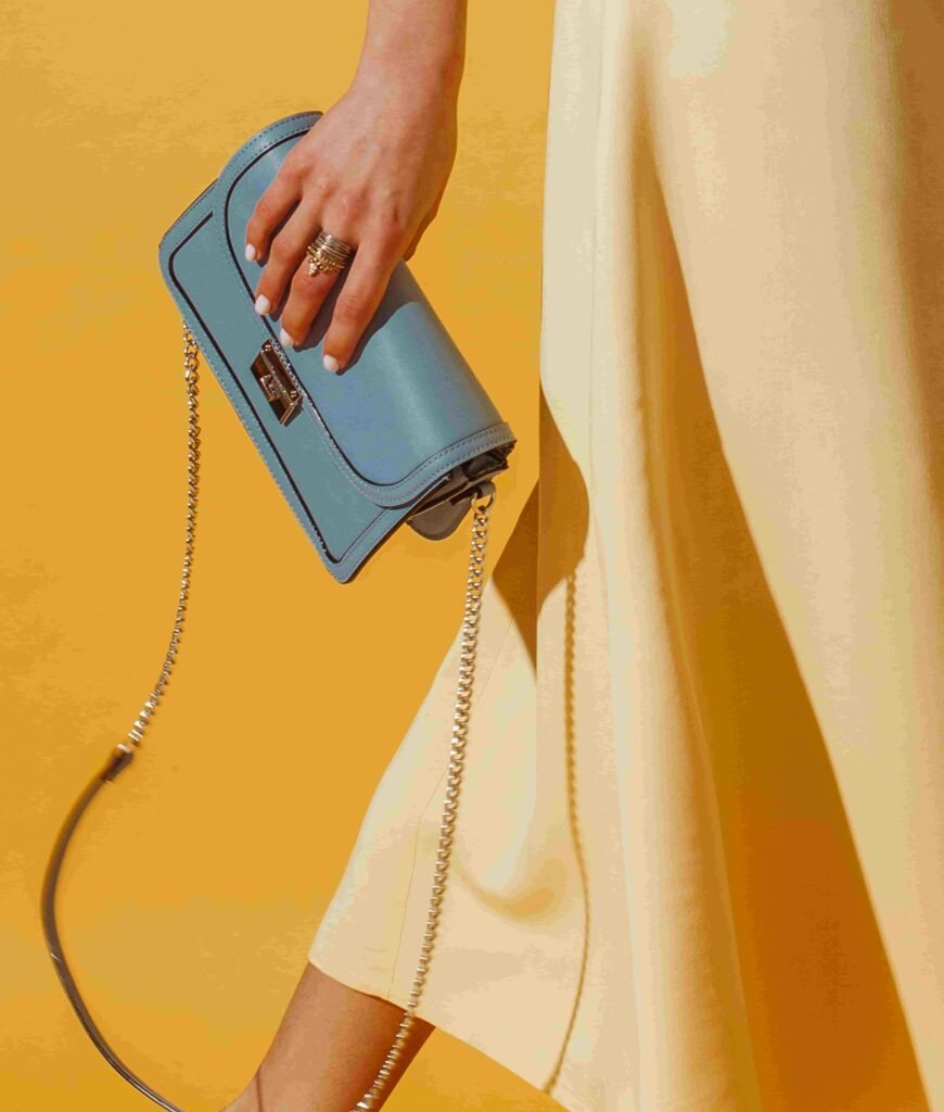 person in yellow dress holding blue purse